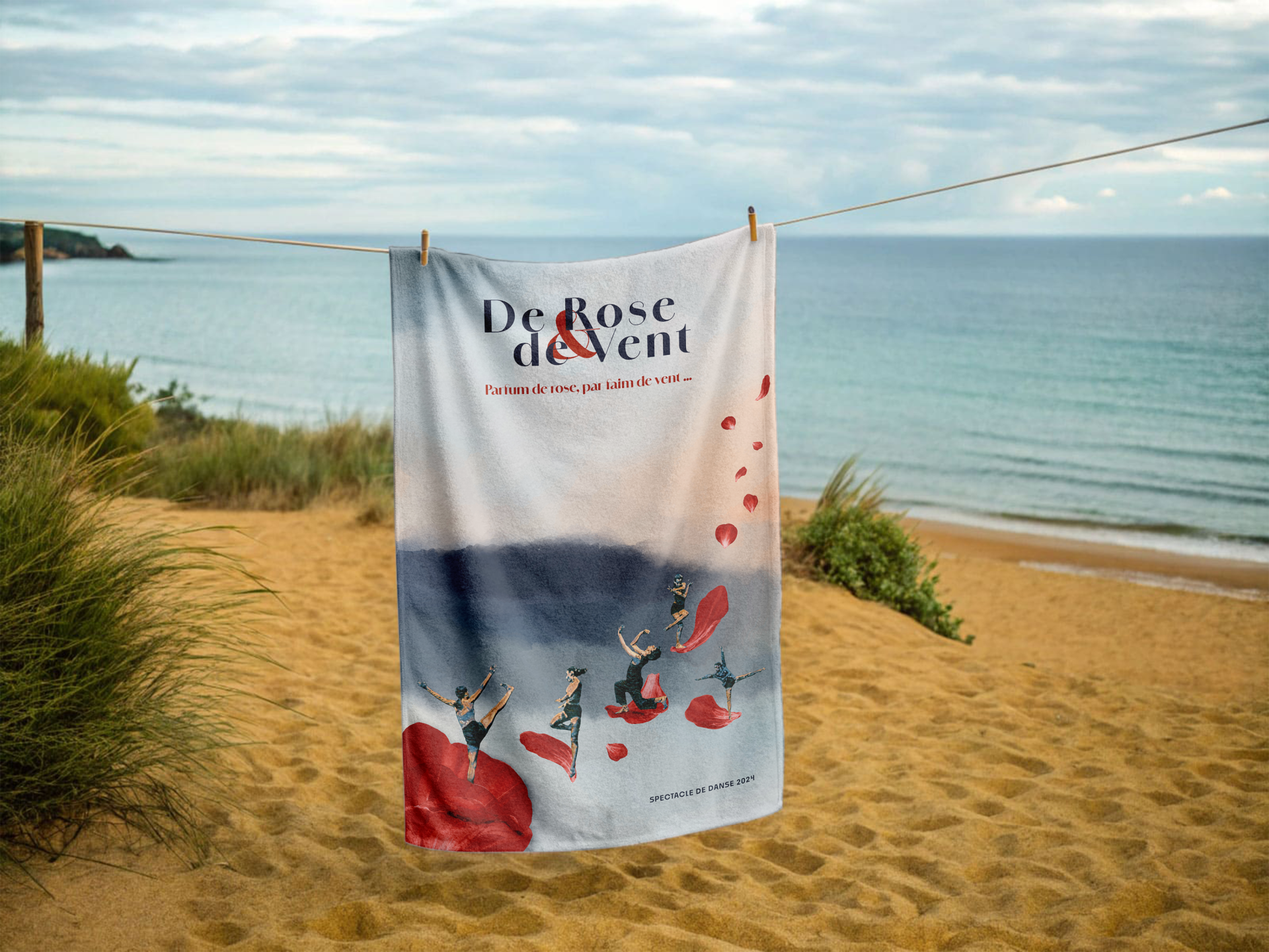 serviette de plage étendue sur un fil. La serviette a comme motif une affiche du spectacle de rose et de vent de l'association l'arbre à danses
